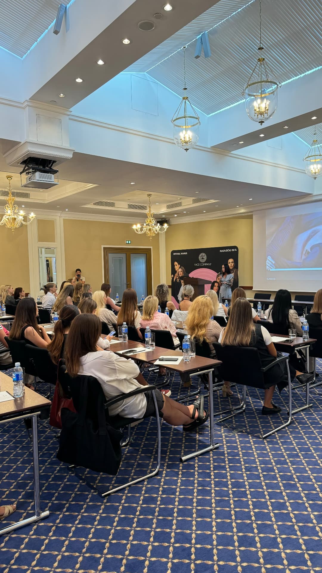 Artists watching a live permanent makeup demonstration on screen